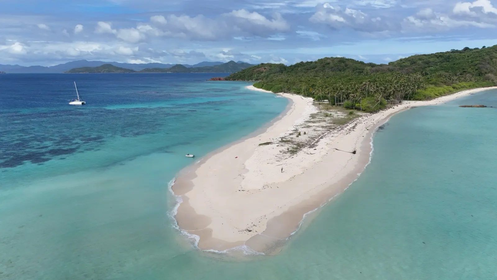 Aerial beach spit, catamaran anchored offshore