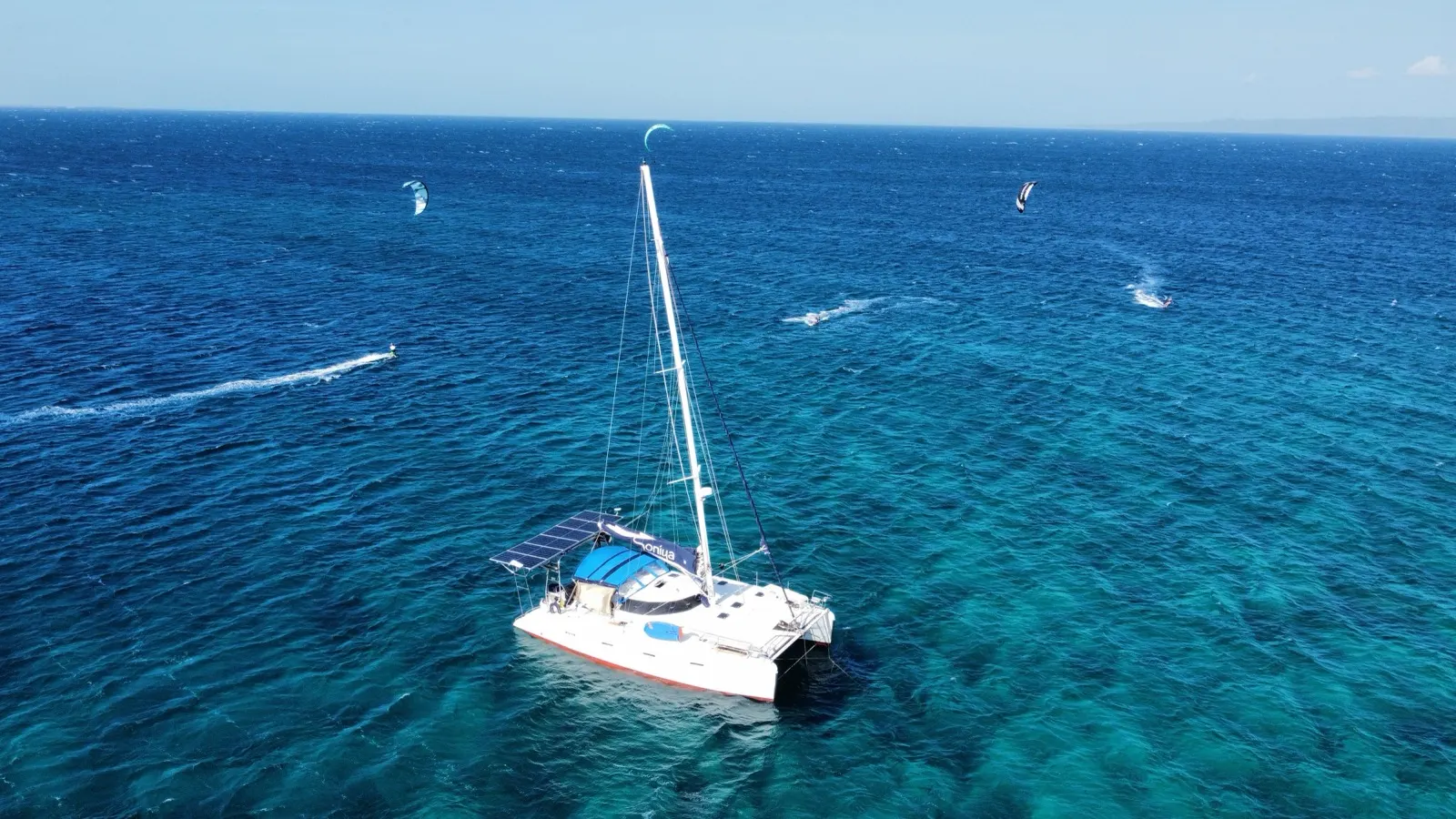 Soniya anchored with kitesurfers riding jetski wake nearby