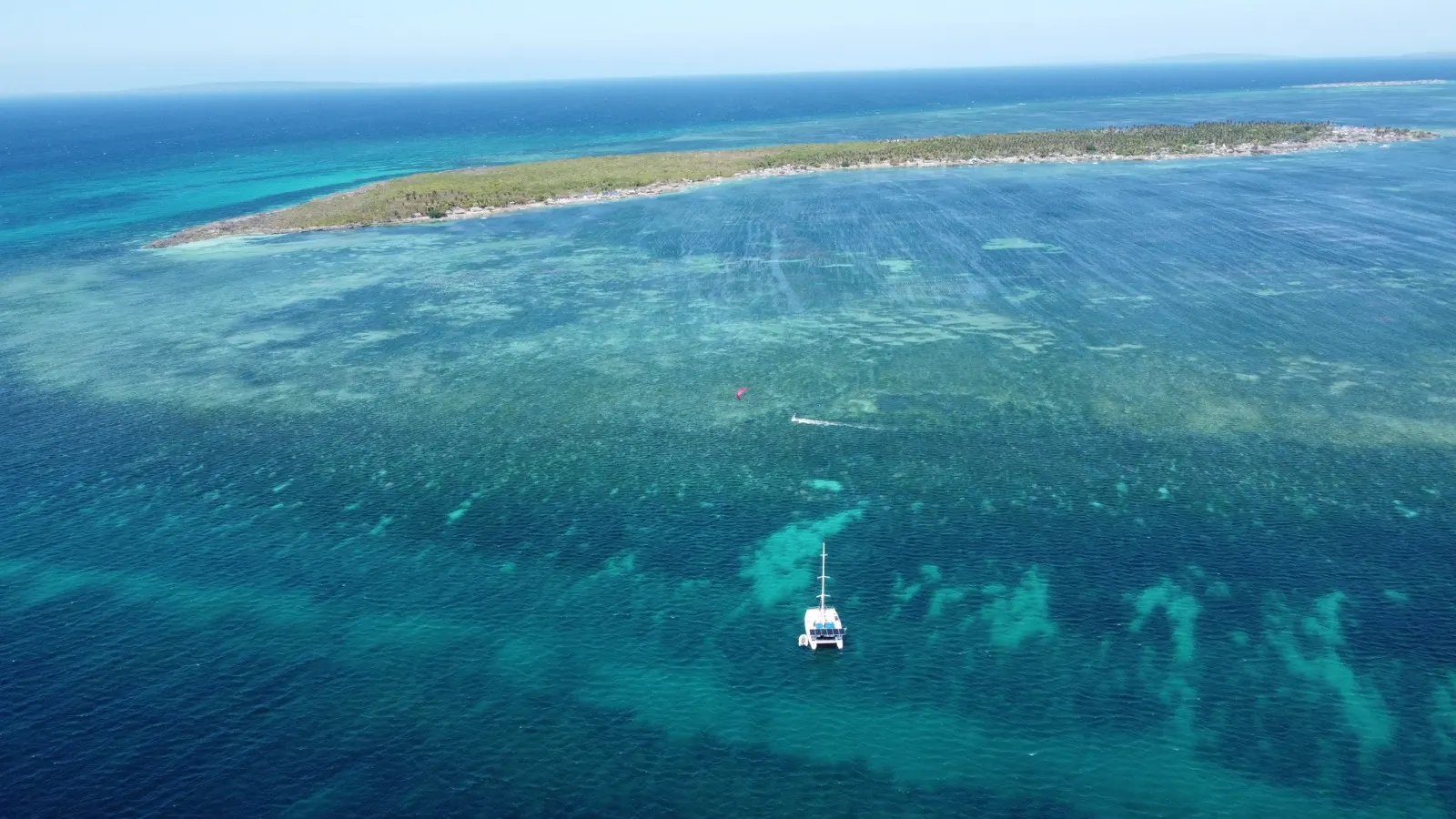 Soniya anchored near island with kites and jetskis around it