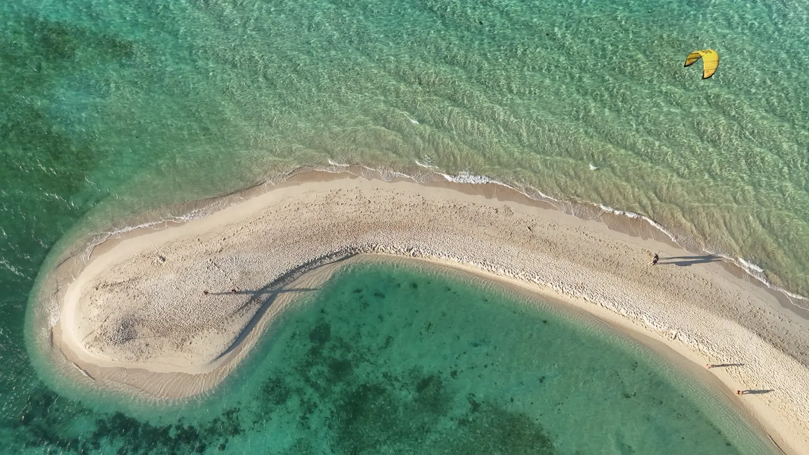 Aerial of catamaran, dinghy and swimmers over reef