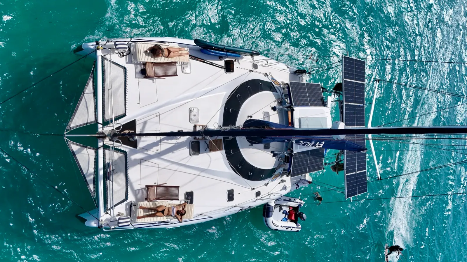 Aerial top-down of Soniya with sunbathers and dinghy alongside