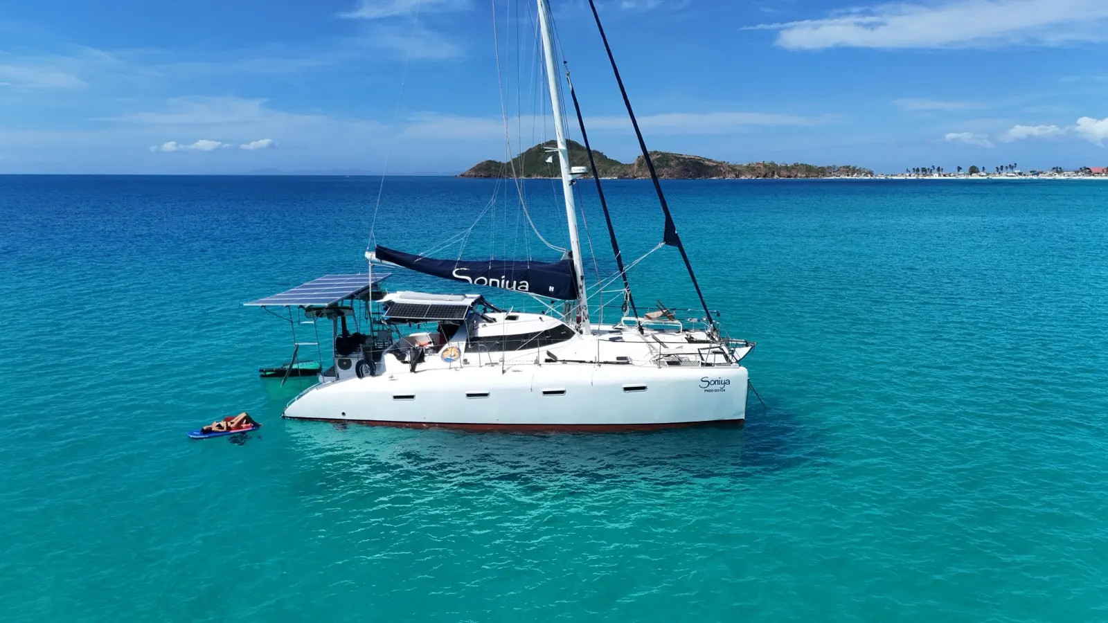 Aerial of catamaran's bow at the edge of a coral reef