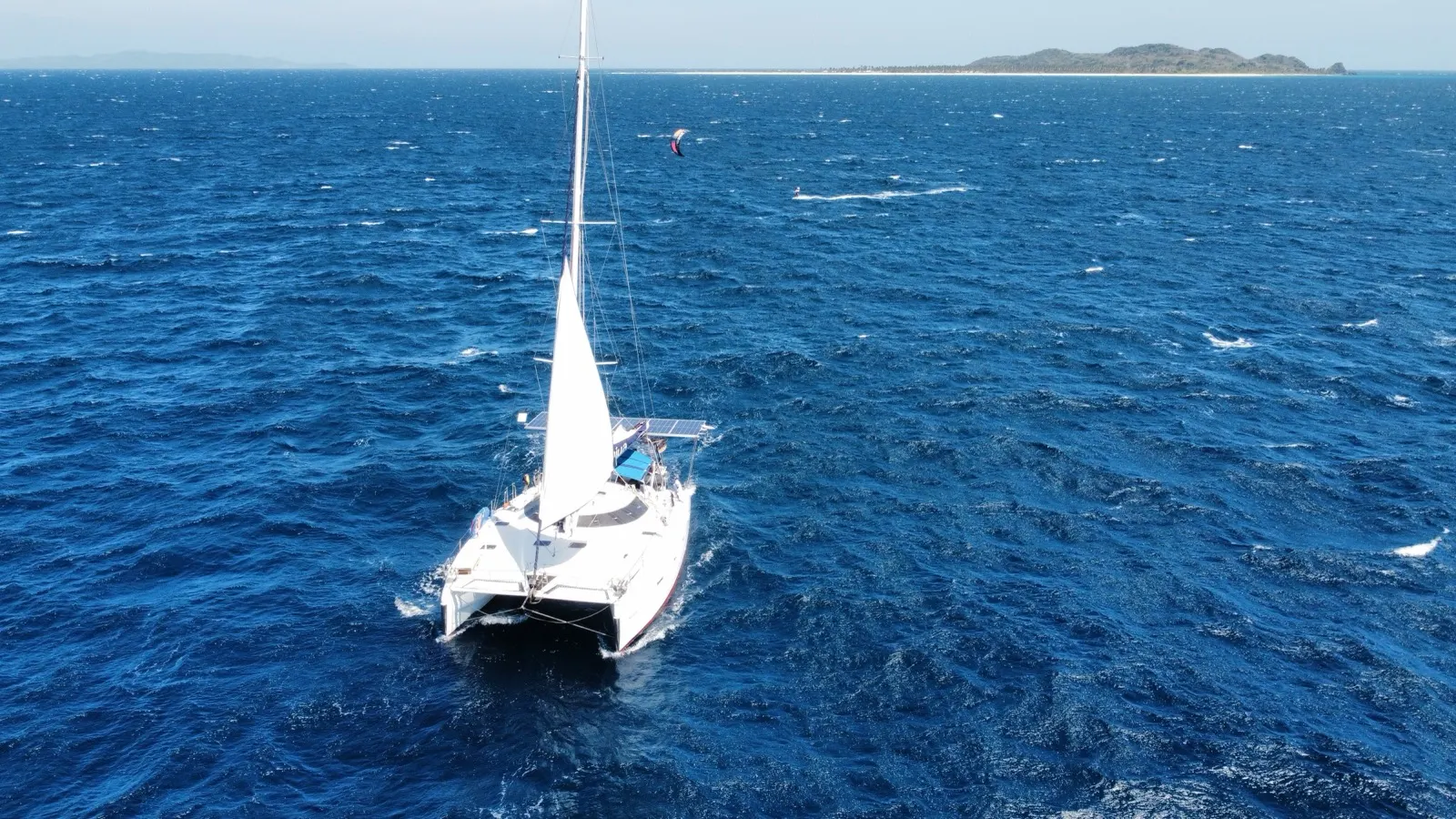 Soniya sailing with a kitesurfer riding in the distance