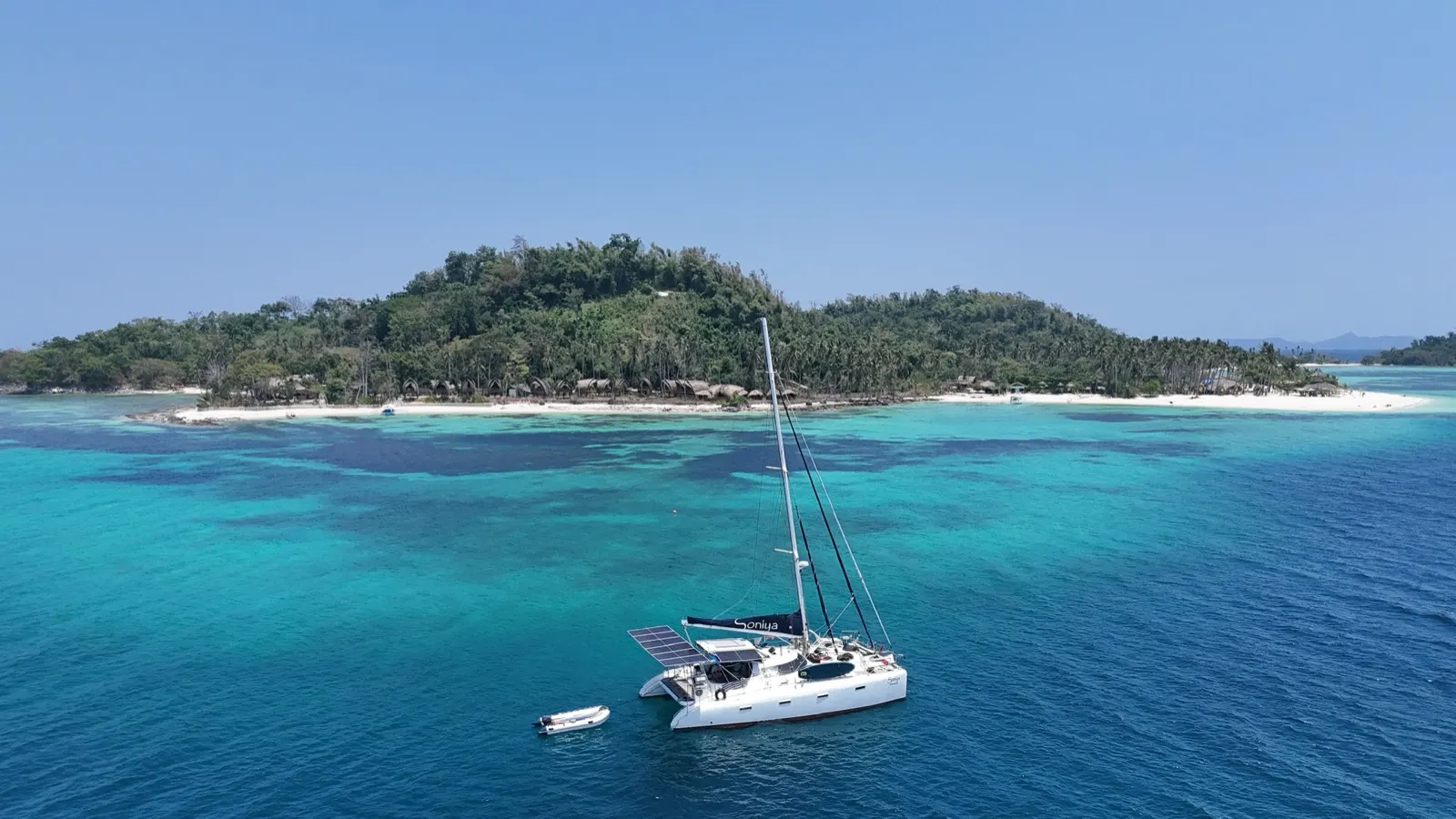 Soniya anchored off a jungle island with white-sand beach