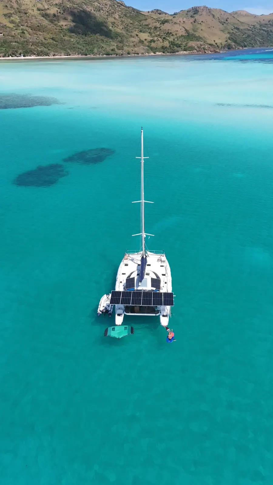 Aerial of a hidden karst lagoon, small boat anchored