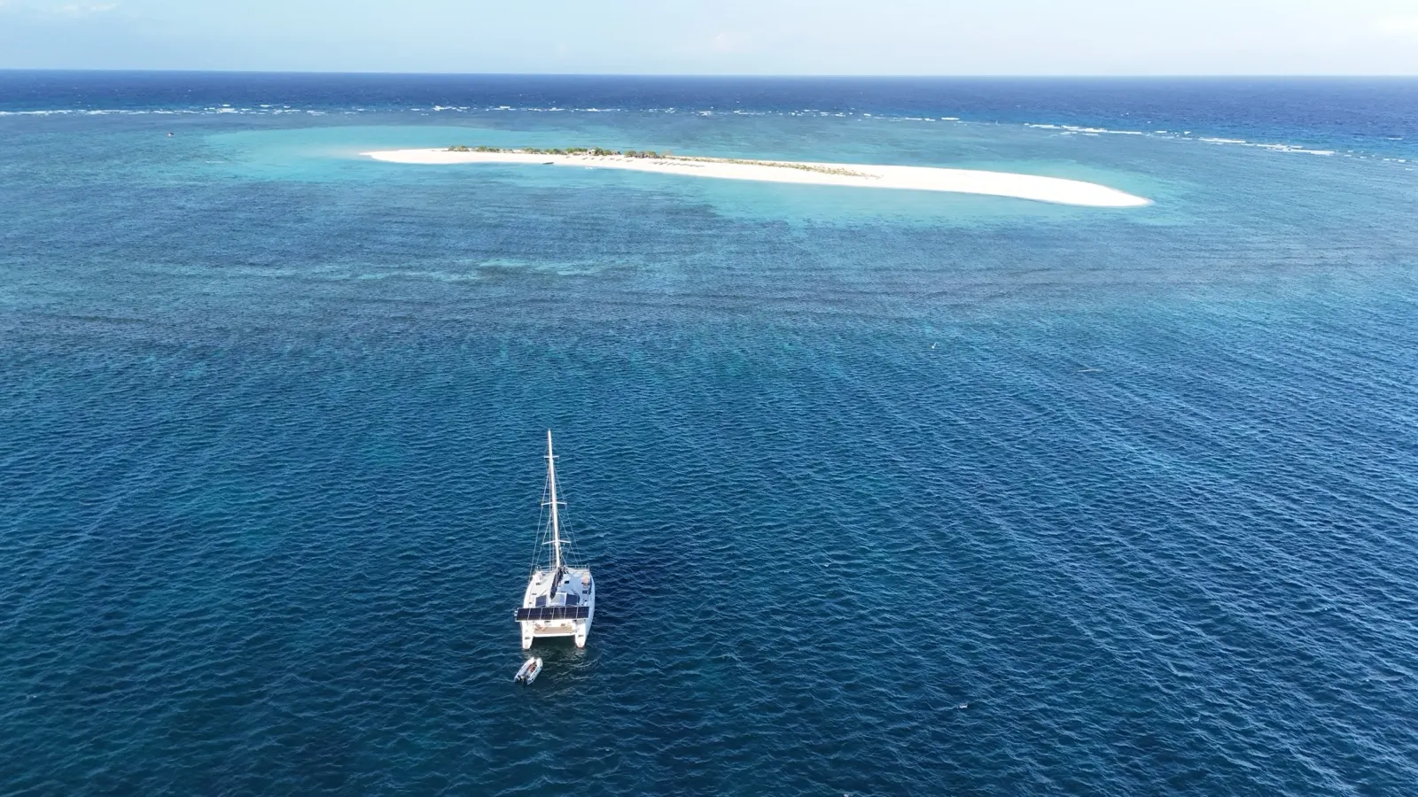Catamaran anchored off a narrow sandbar island