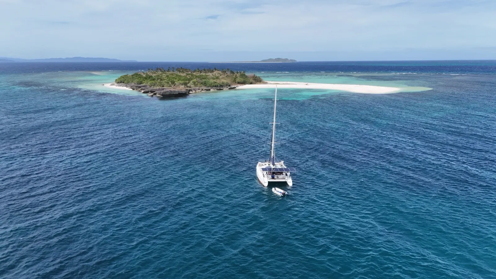 Top-down aerial of catamaran beside reef