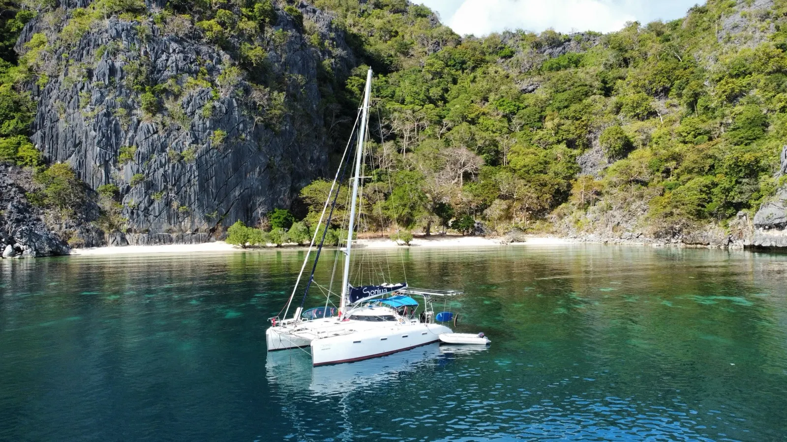 Catamaran near cliffs and beach, Soniya name visible