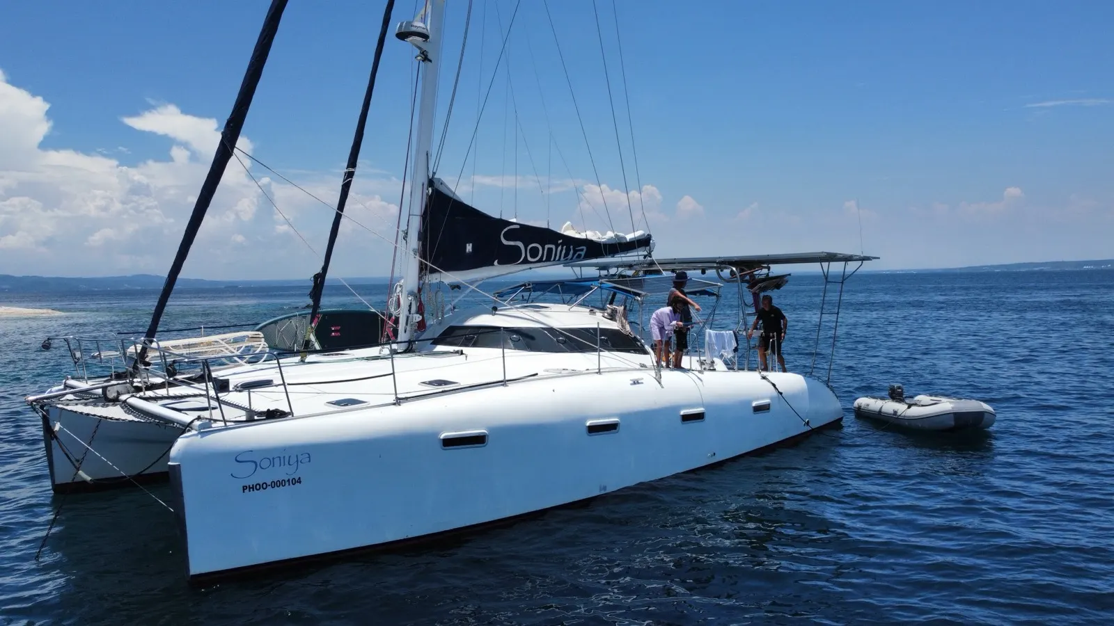 Side view of Soniya catamaran with crew on deck