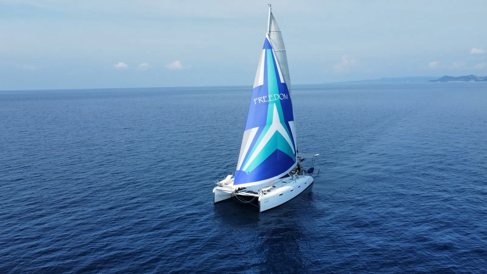 Catamaran under "FREEDOM" spinnaker, side view