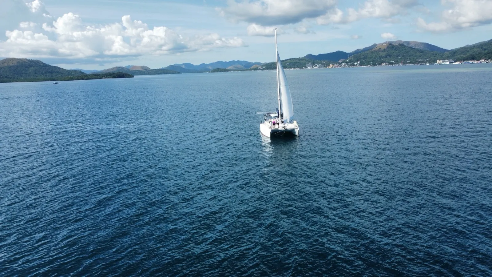 Soniya under sail with a group of guests standing on deck