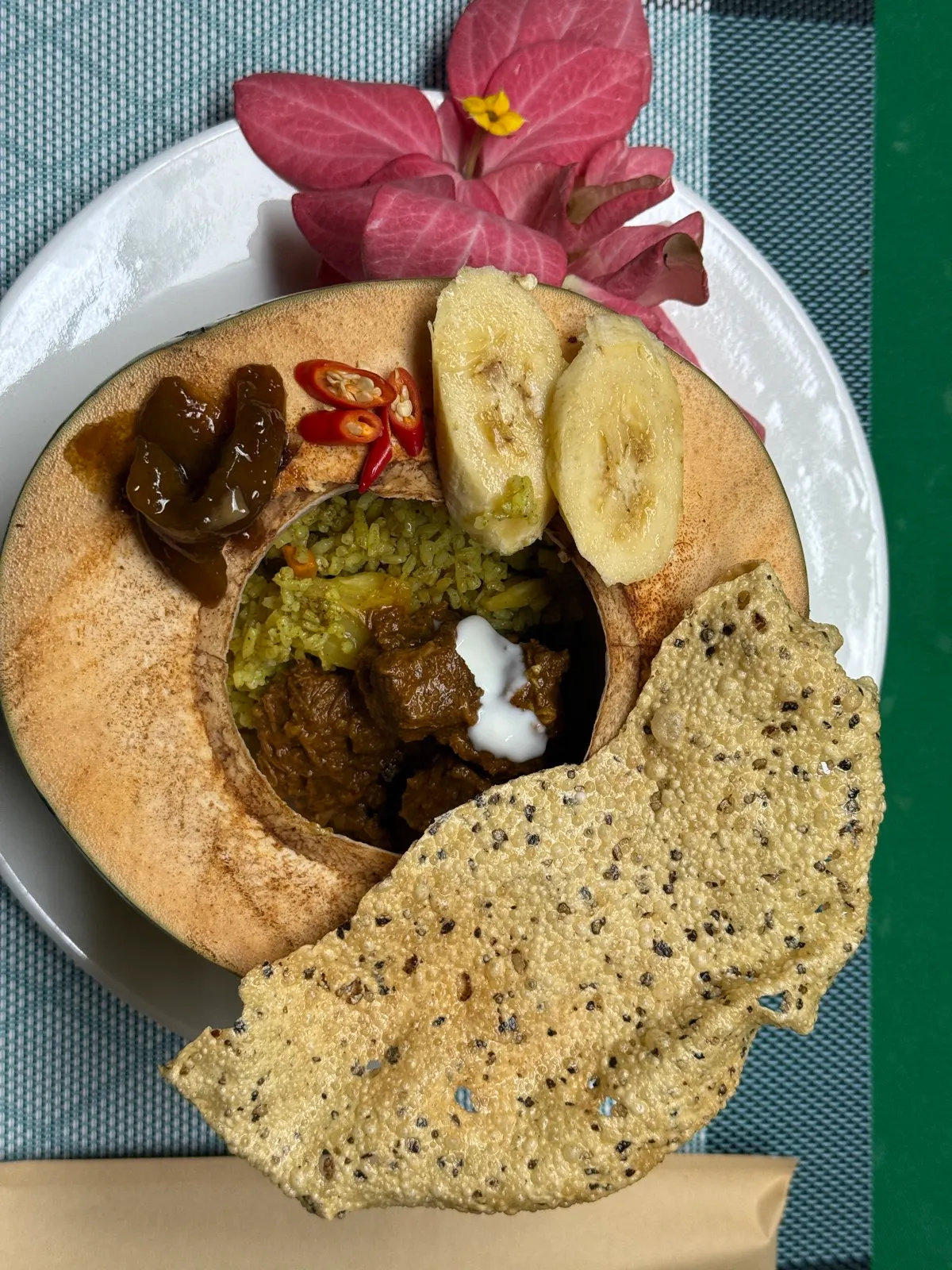 Curry served in coconut shell with banana and crackers