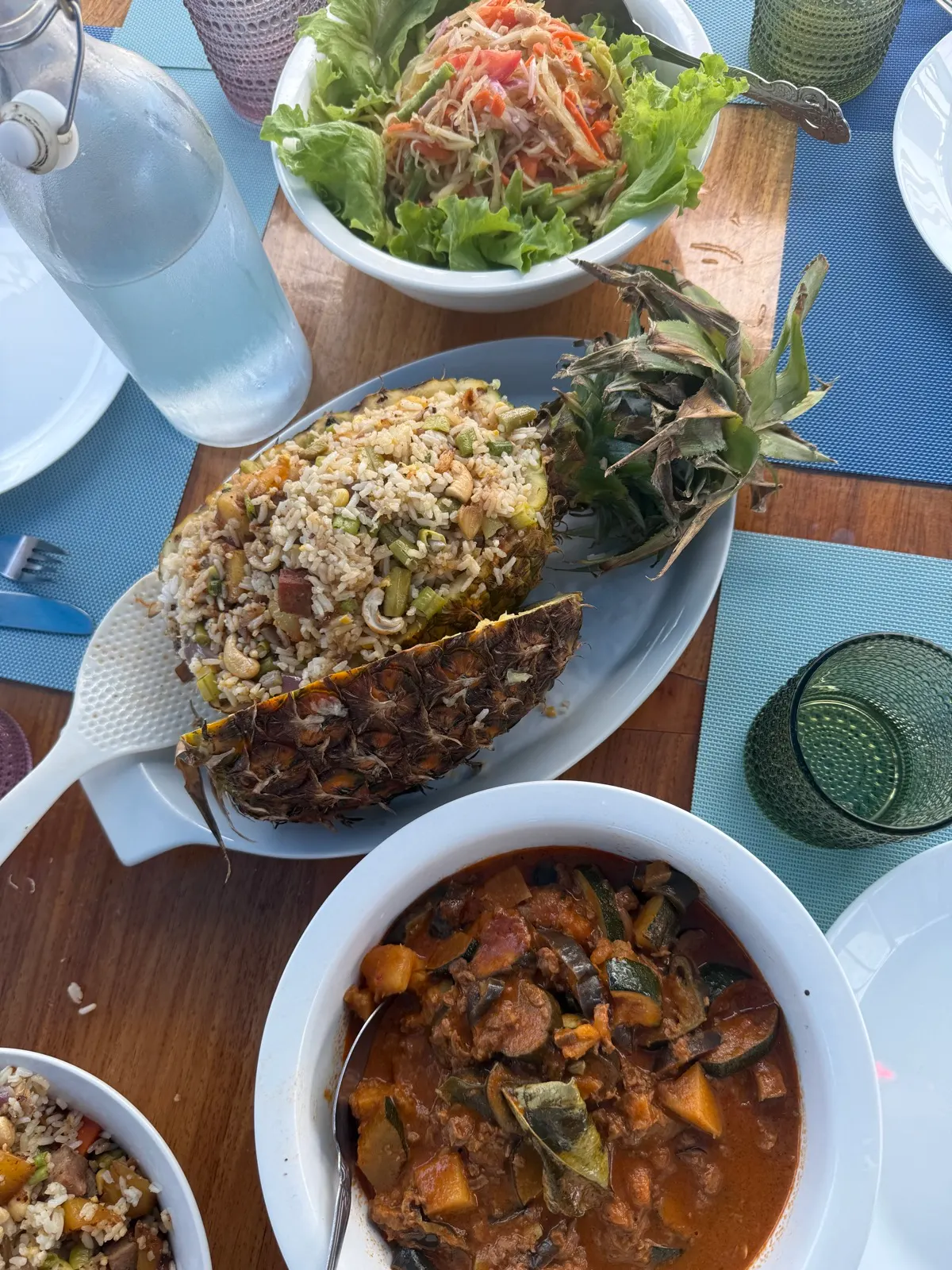 Overhead spread: pineapple fried rice, salad, curry