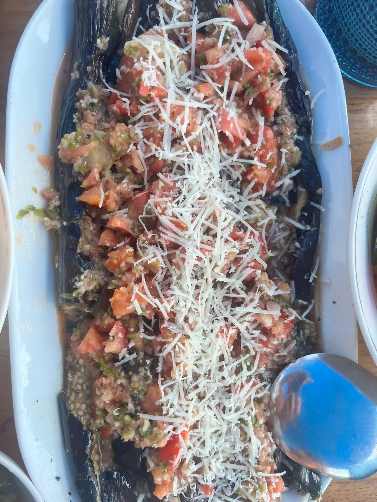 Grilled eggplant dish topped with tomato and cheese