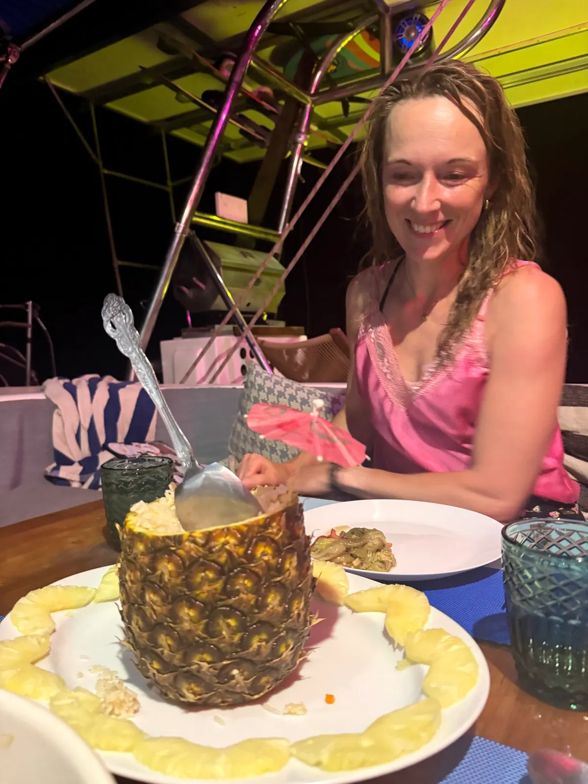 Woman with pineapple cocktail at night table