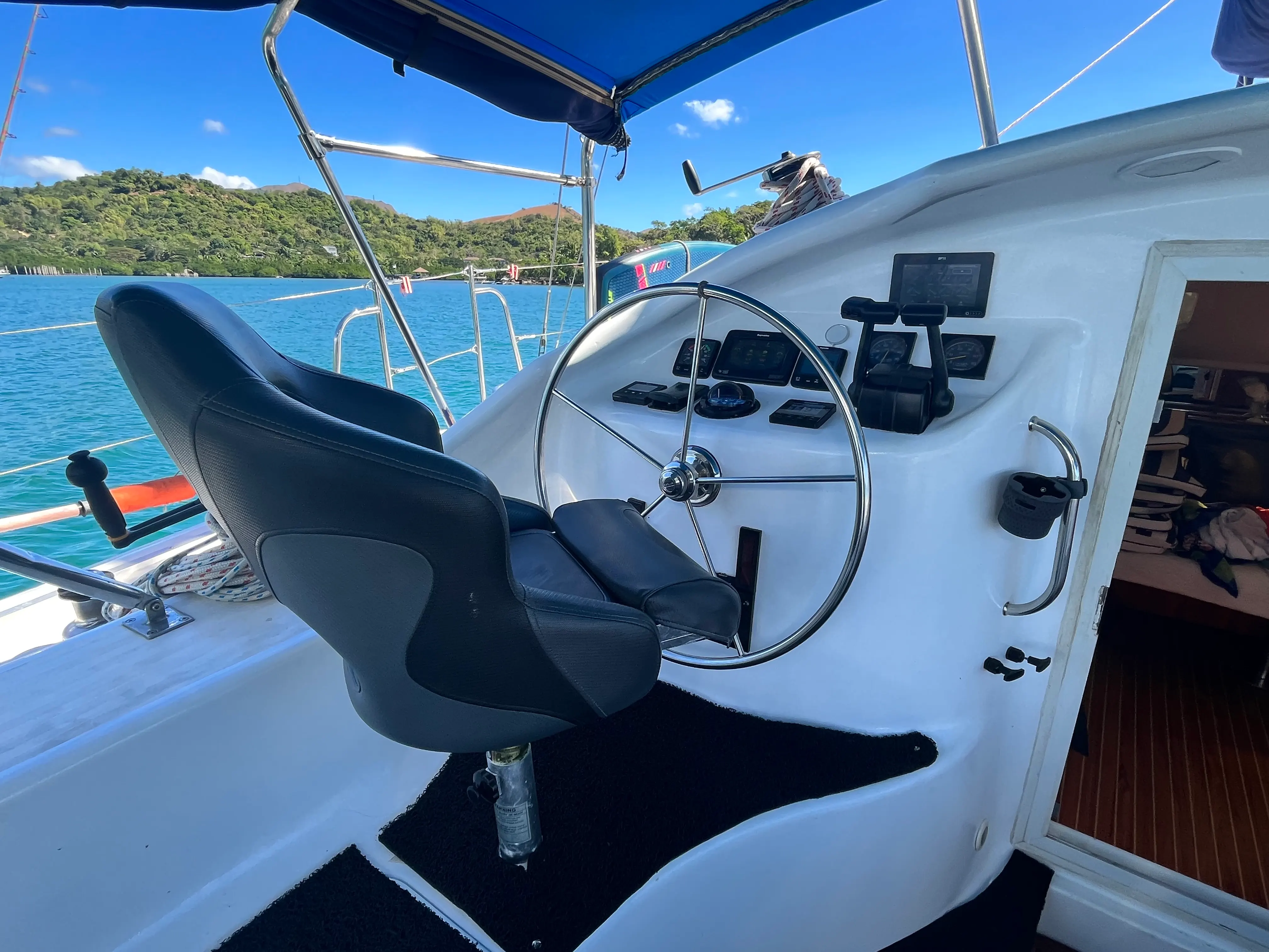 Outdoor helm station aboard Soniya with steering wheel and chartplotter