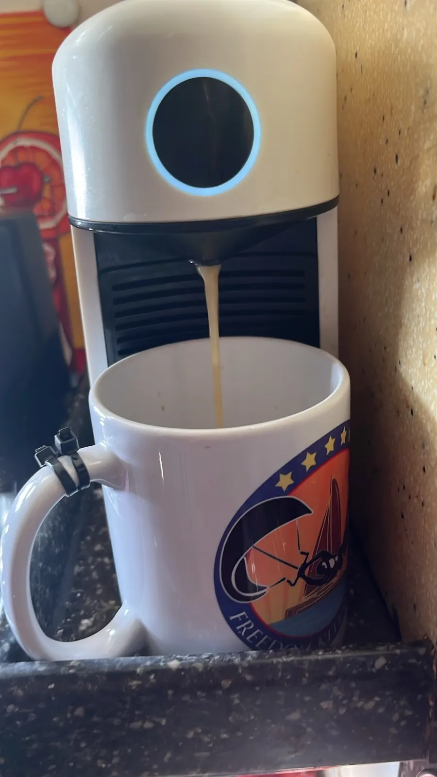 Espresso pouring into a Freedom Kitesurfing branded mug