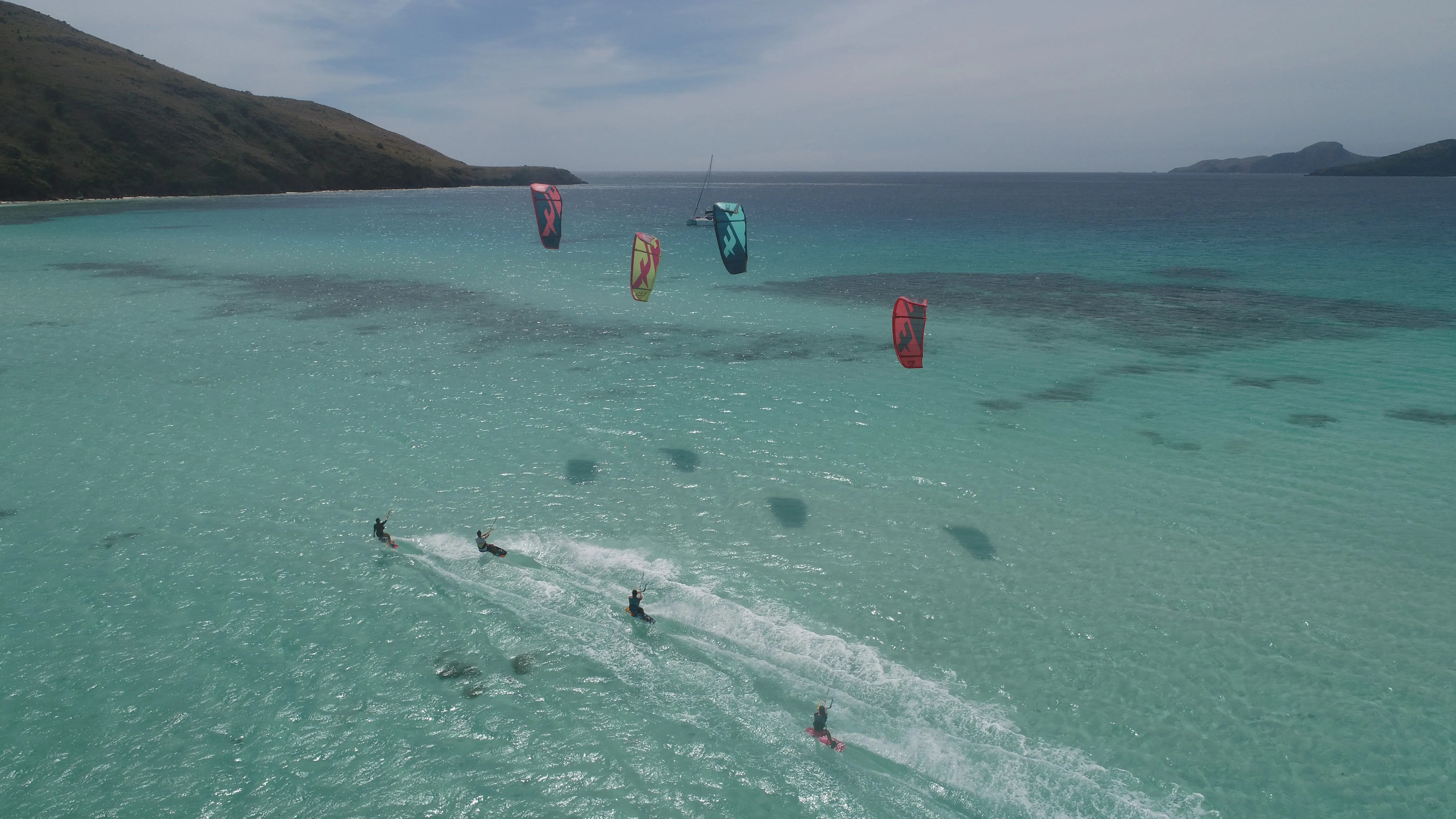 Kiteboarder near a sandbar with kites at dusk