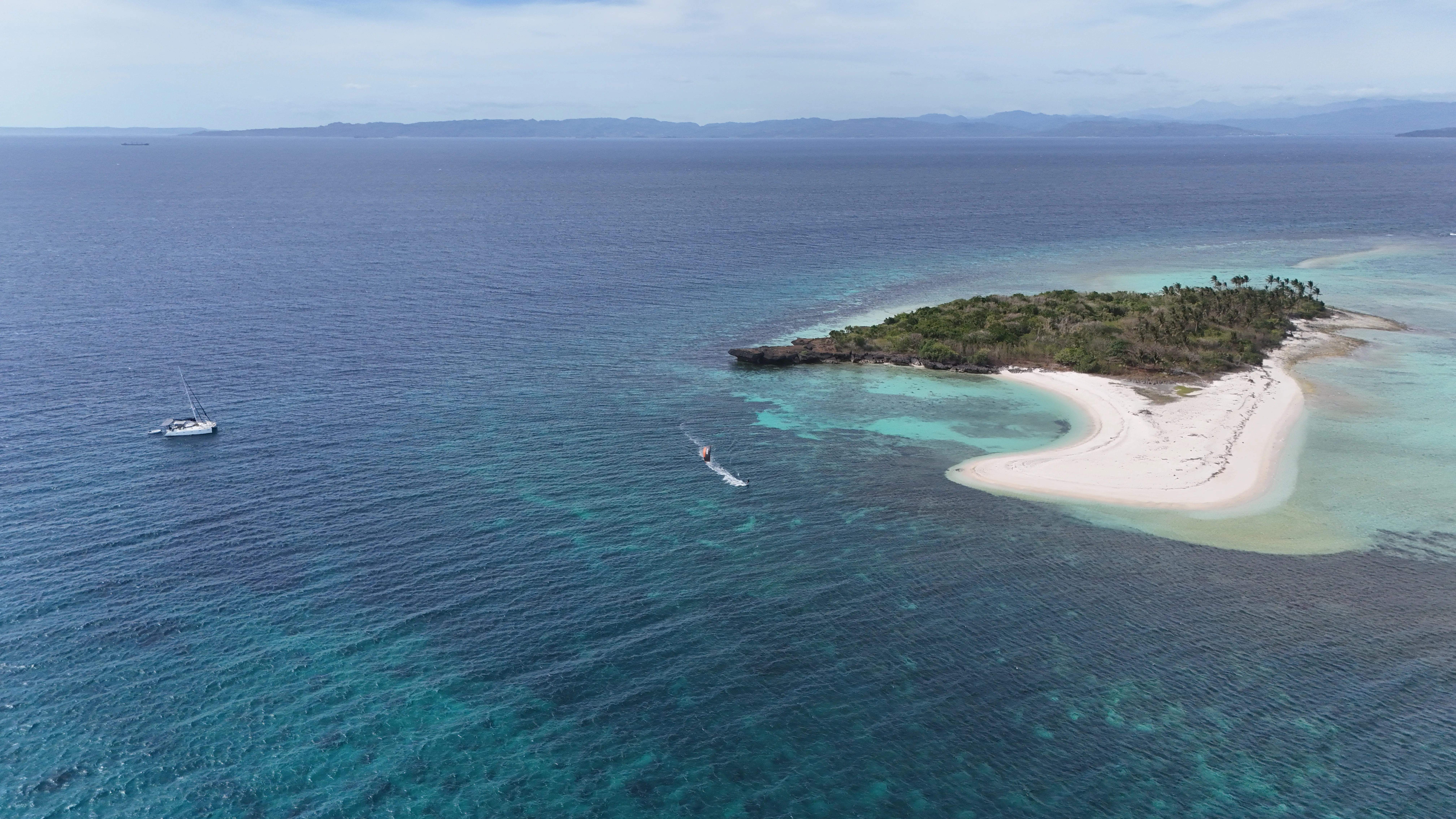Low-angle view of a kiteboarder against a tropical backdrop