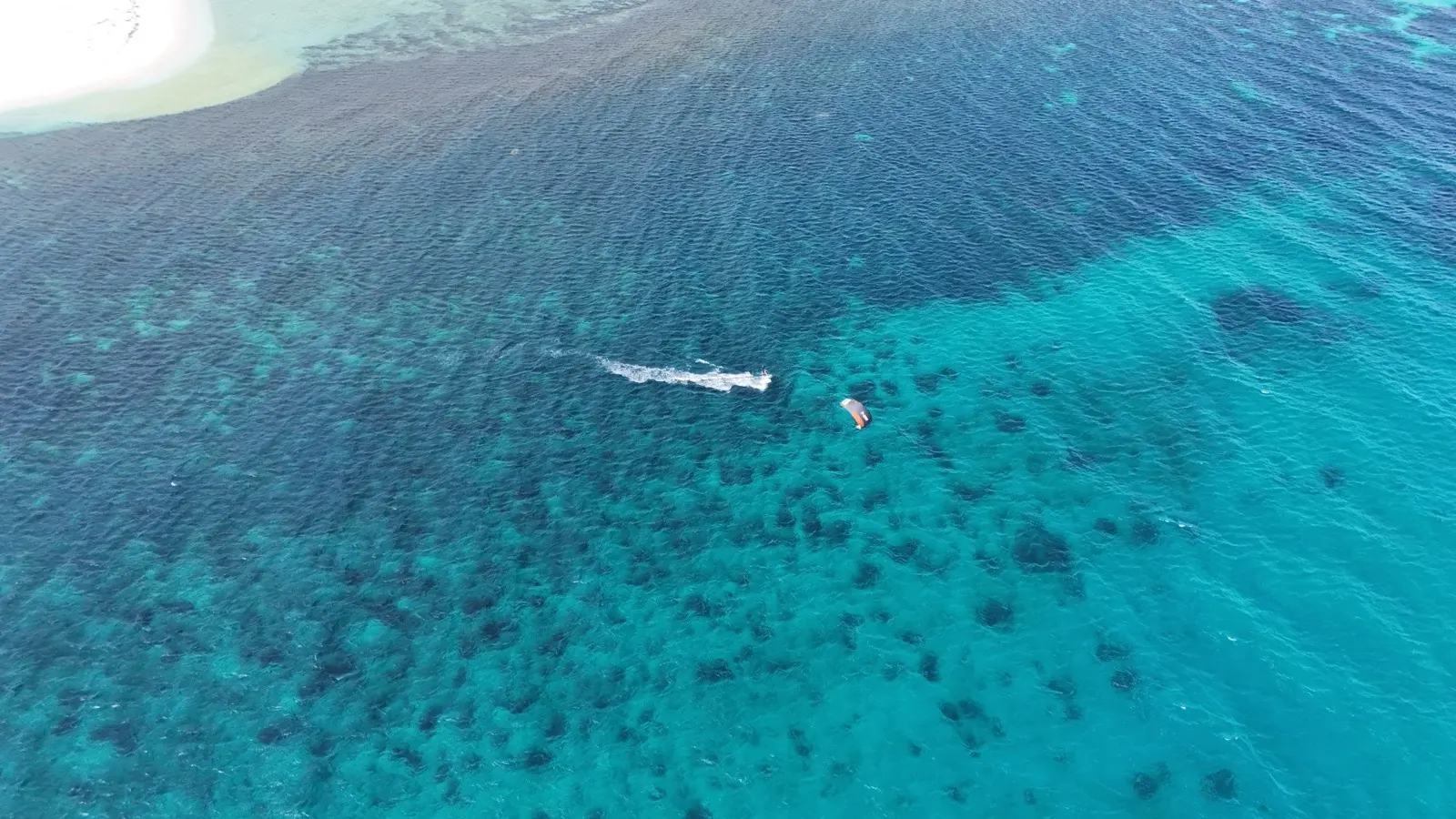 Aerial close-up of kitesurfer riding with kite overhead