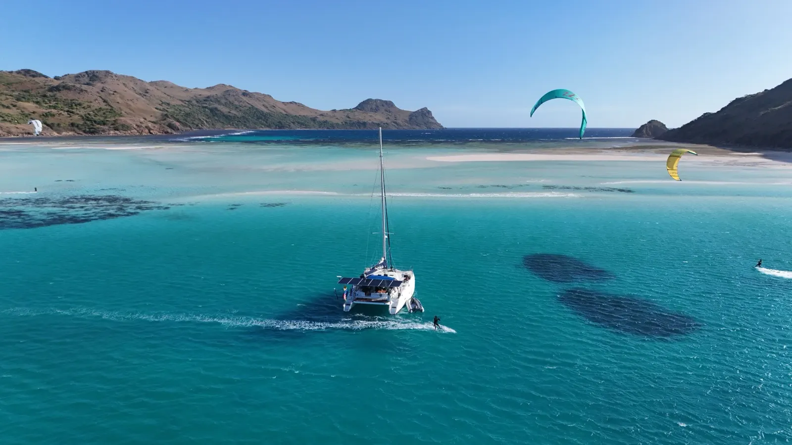 Catamaran with two kites flying nearby