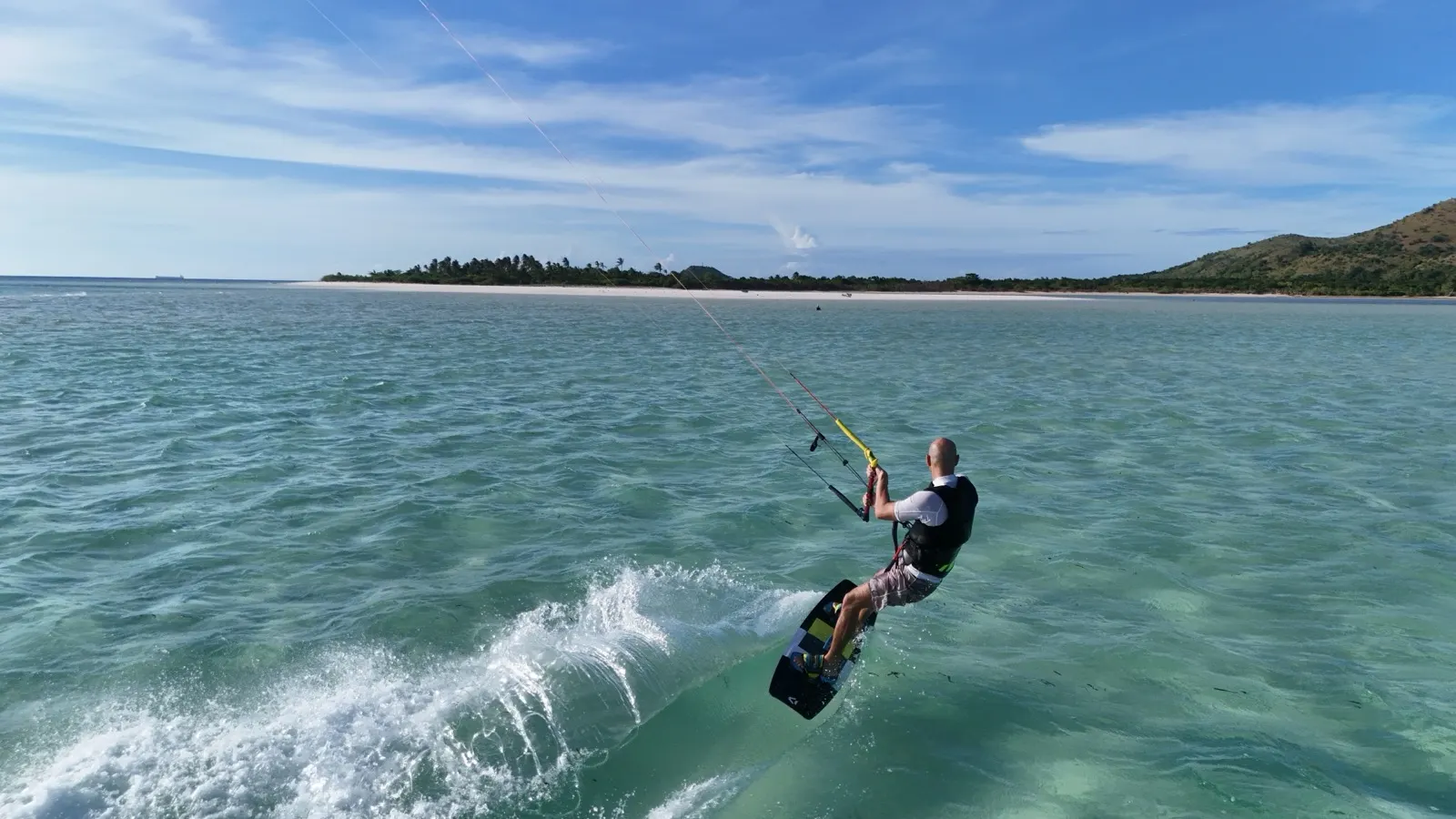 Kitesurfer carving spray close to camera