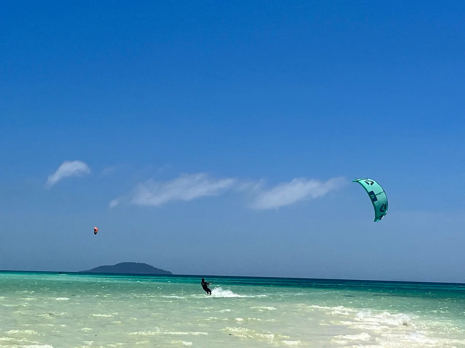 Kitesurfer riding with second kite/rider distant