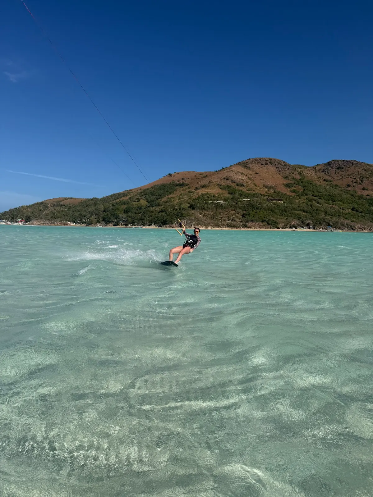 Aerial vertical shot of kiter riding along coast