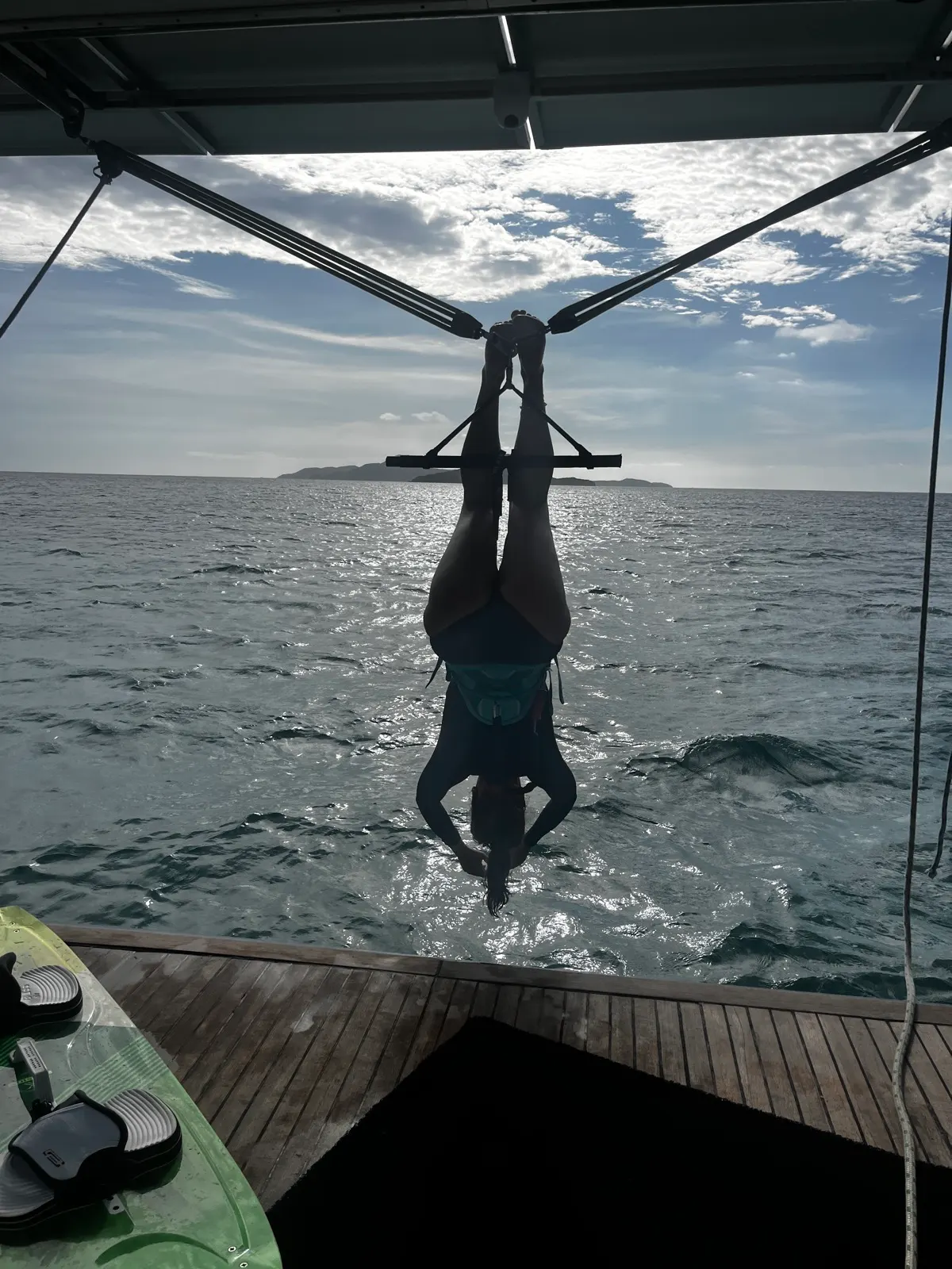 Silhouette of kitesurfer riding near boat