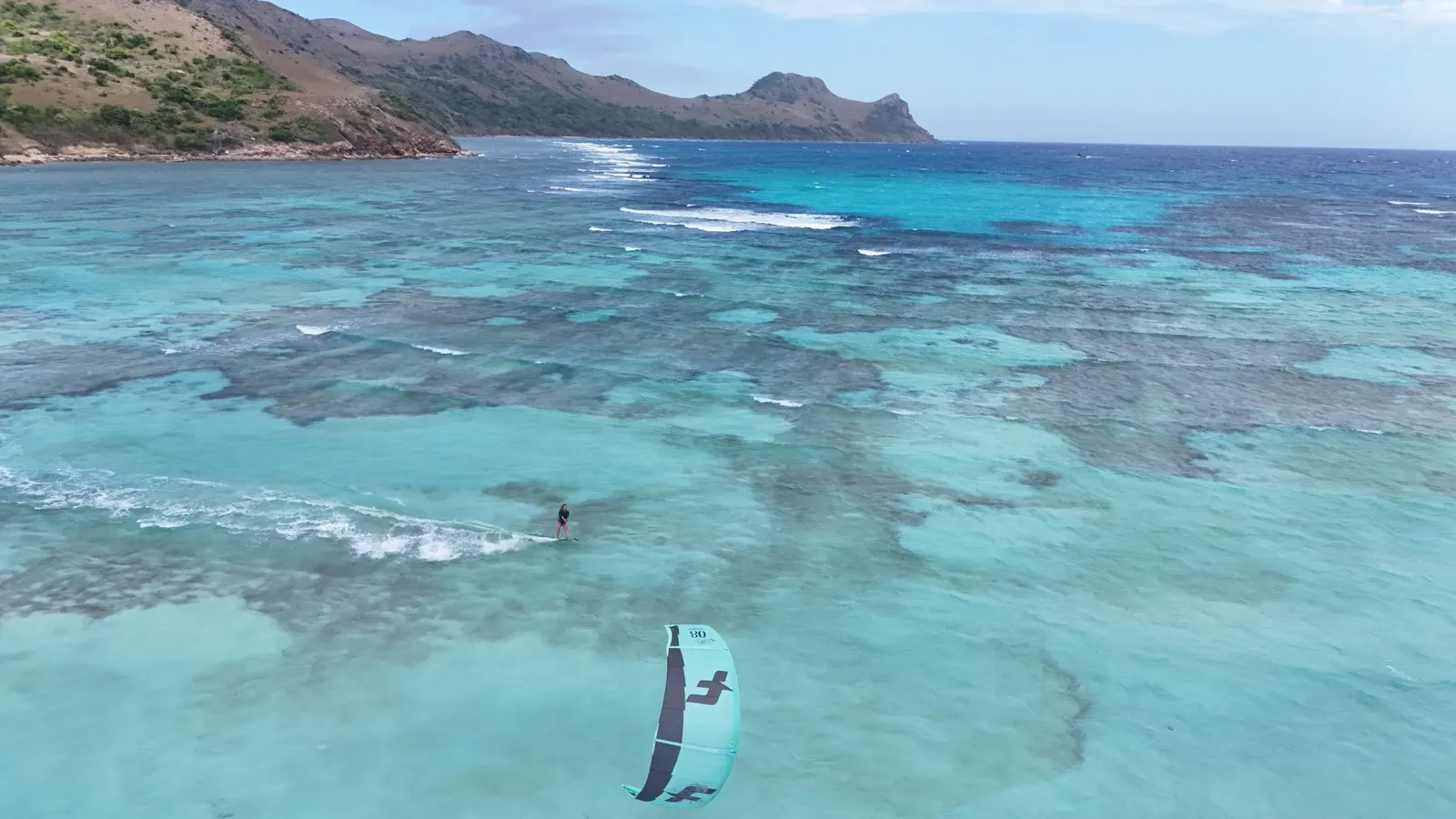 Kitesurfer over reef, second kite in distance