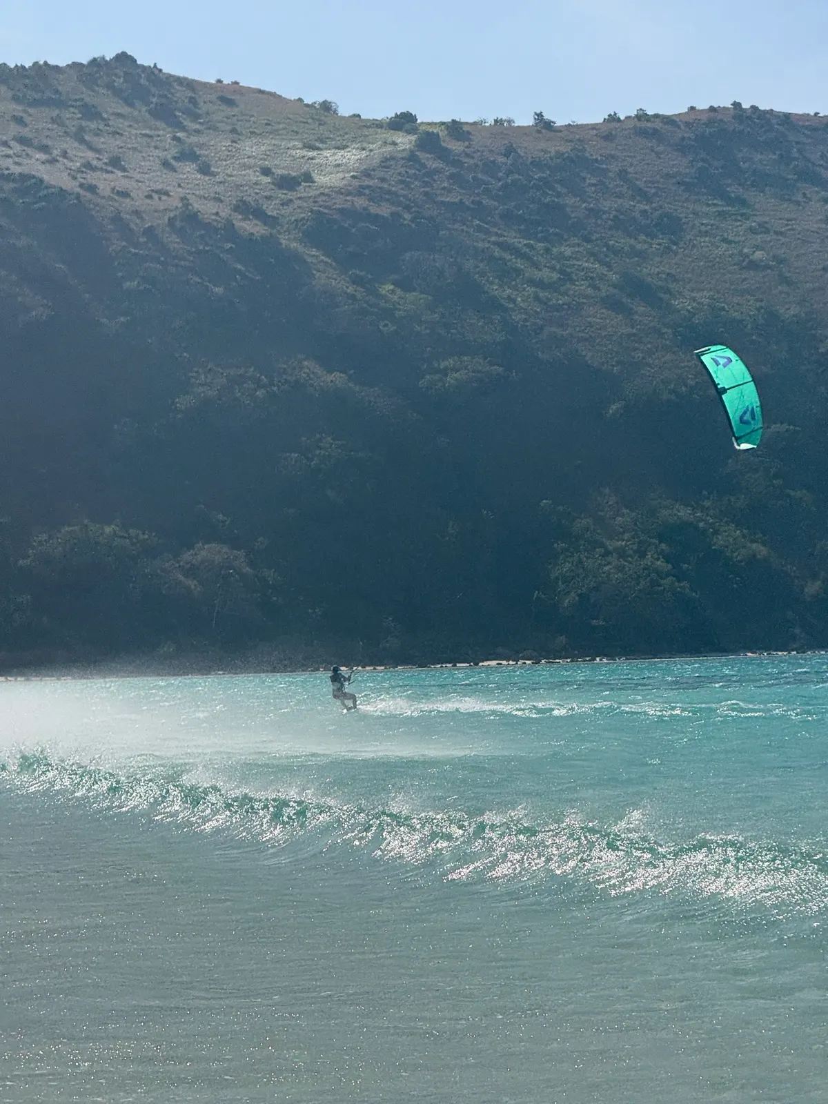 Aerial view of kiteboarder near limestone shoreline