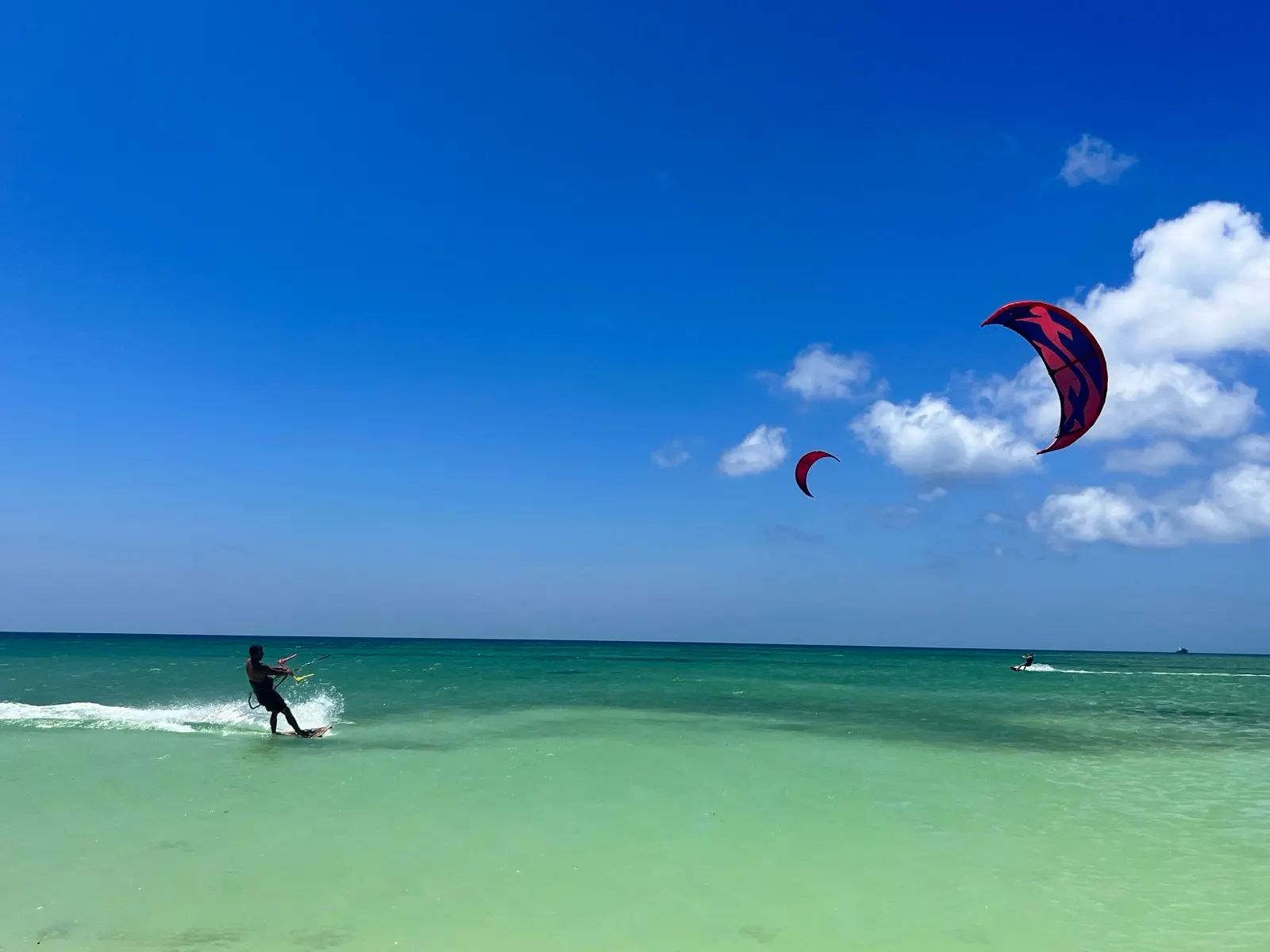 Two kites flying high against blue sky
