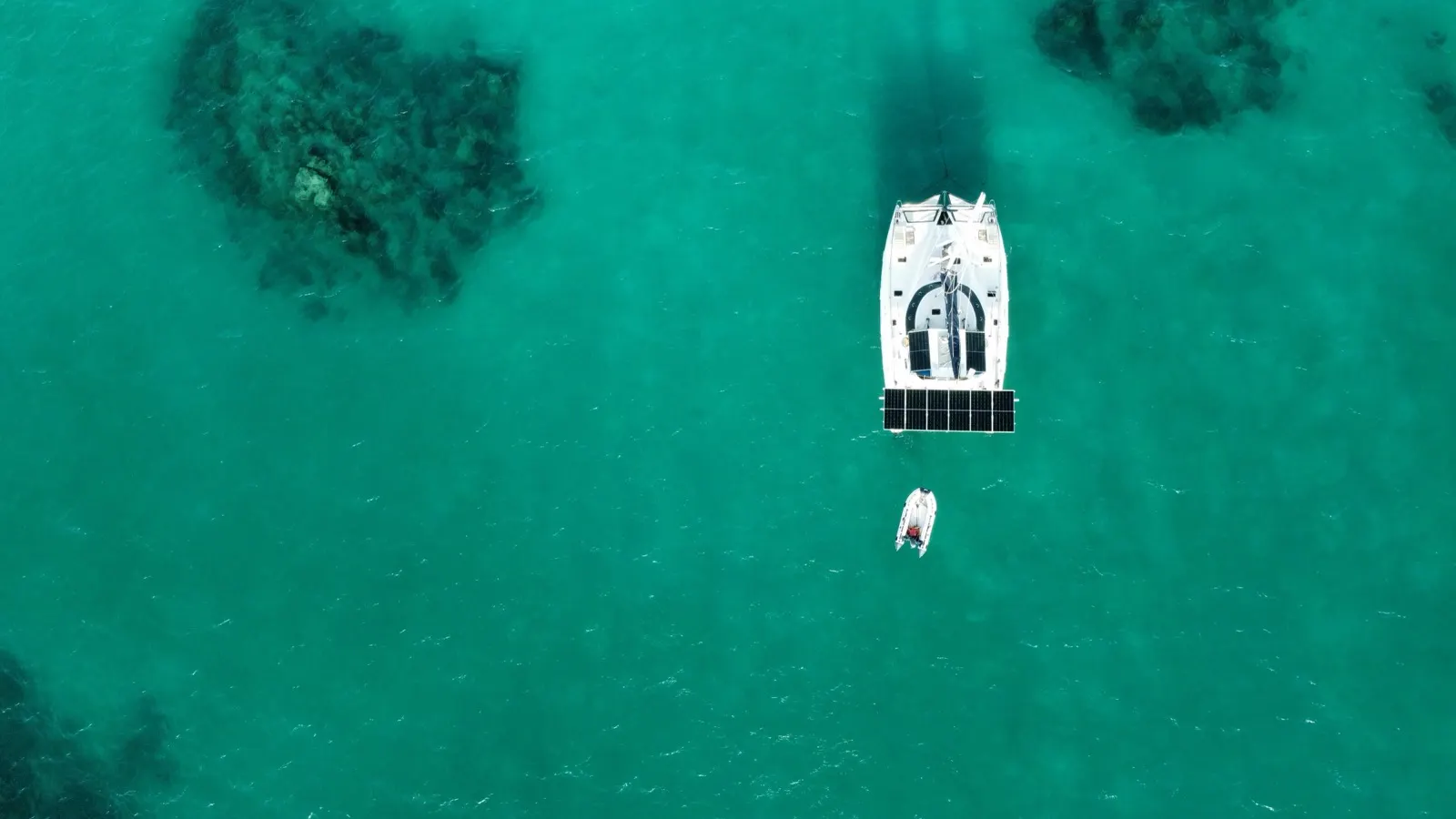 Directly-overhead aerial of anchored catamaran