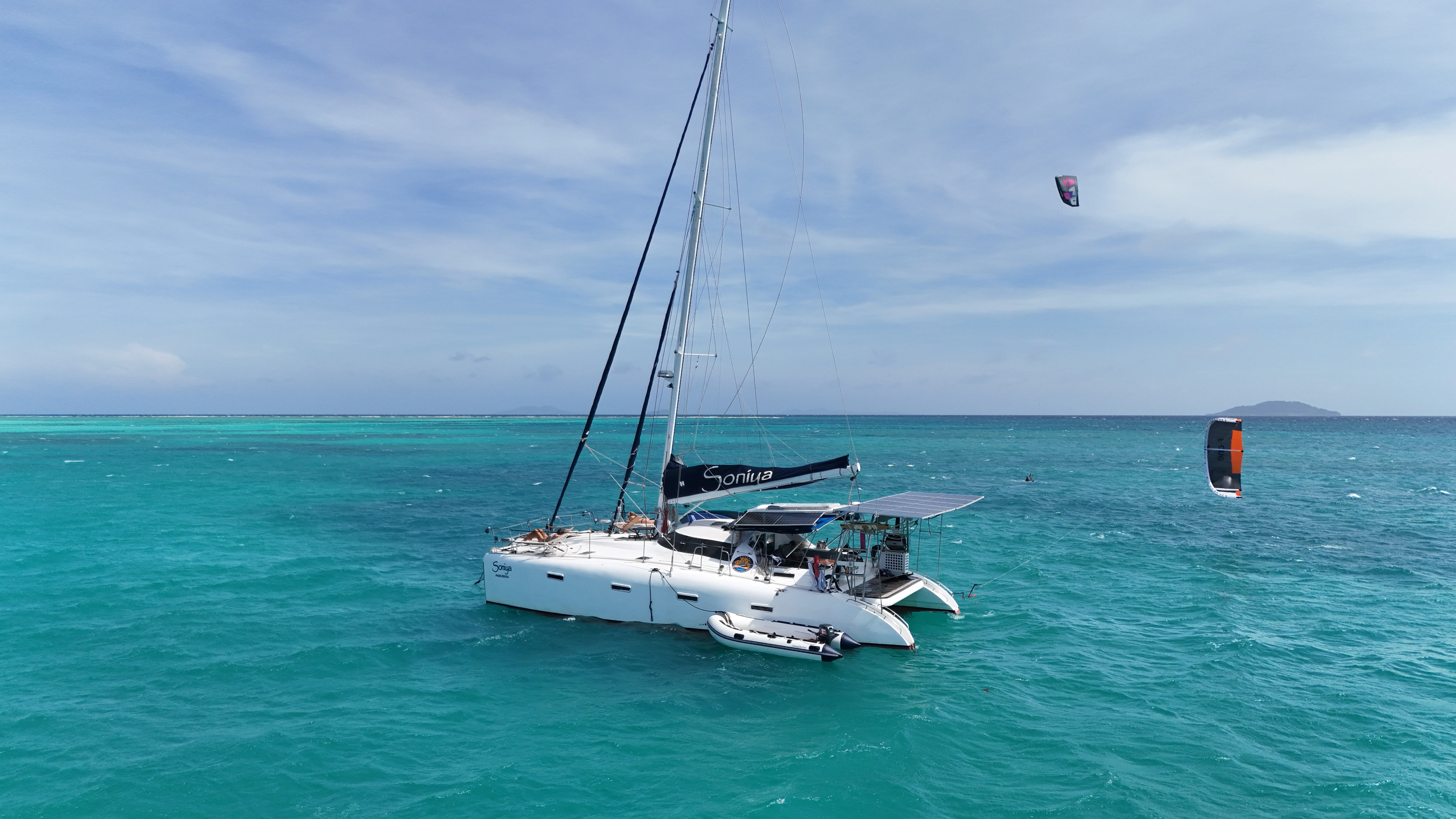 Aerial view of Soniya anchored with two kitesurfers flying nearby off Palawan