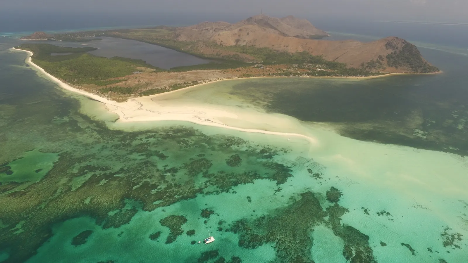 Aerial of catamaran anchored off a sandbar lagoon