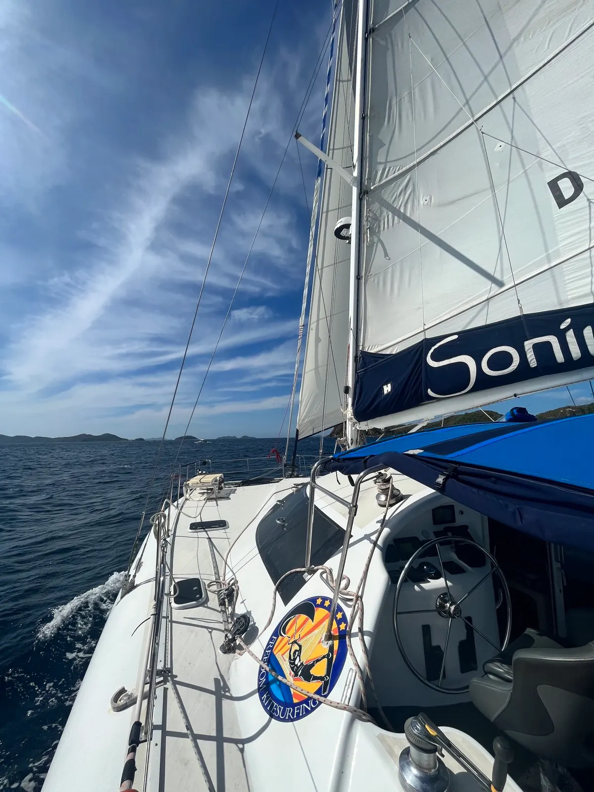 Looking aft along sail and wheel, Freedom Kitesurfing badge