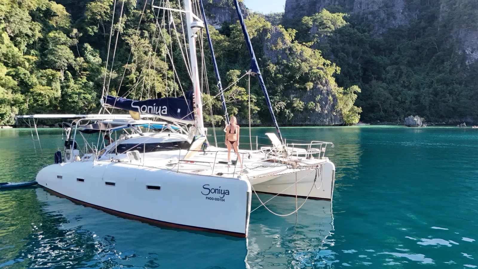 Soniya sailing across a wide calm bay flanked by islands