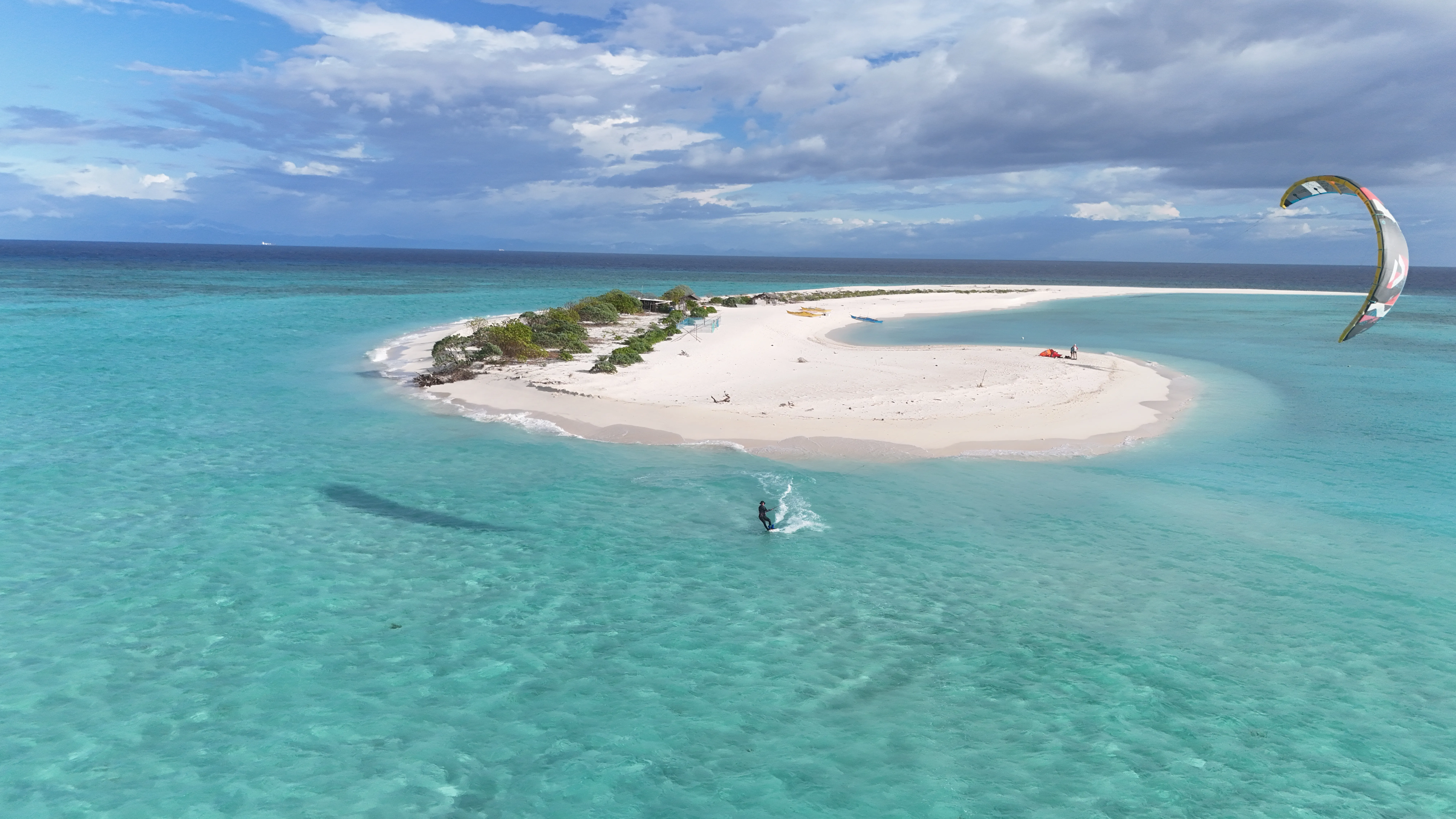 Wide aerial view of a kitesurfer riding near Seco Island