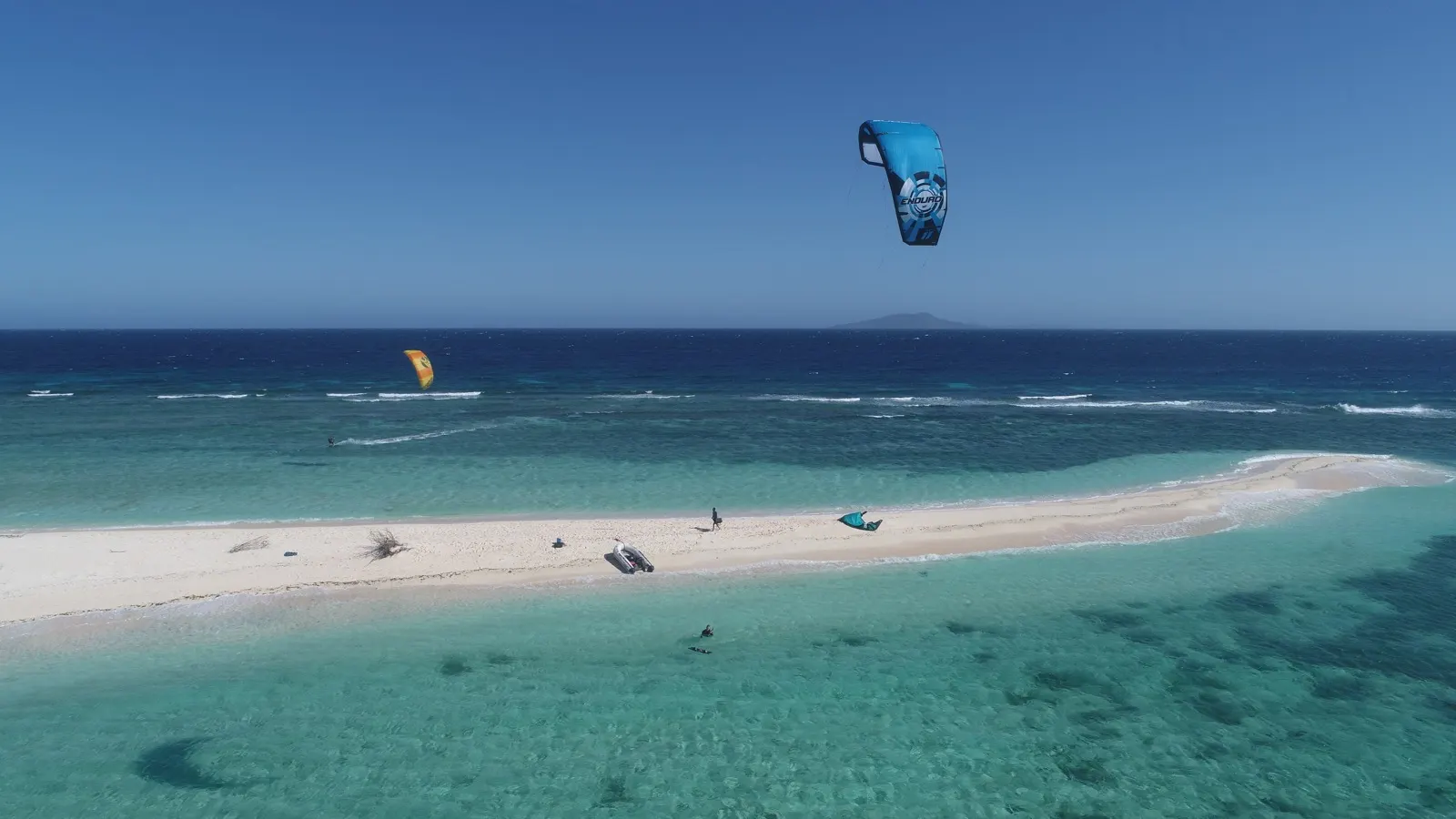 Kitesurfers on sandbar and in water with kites up