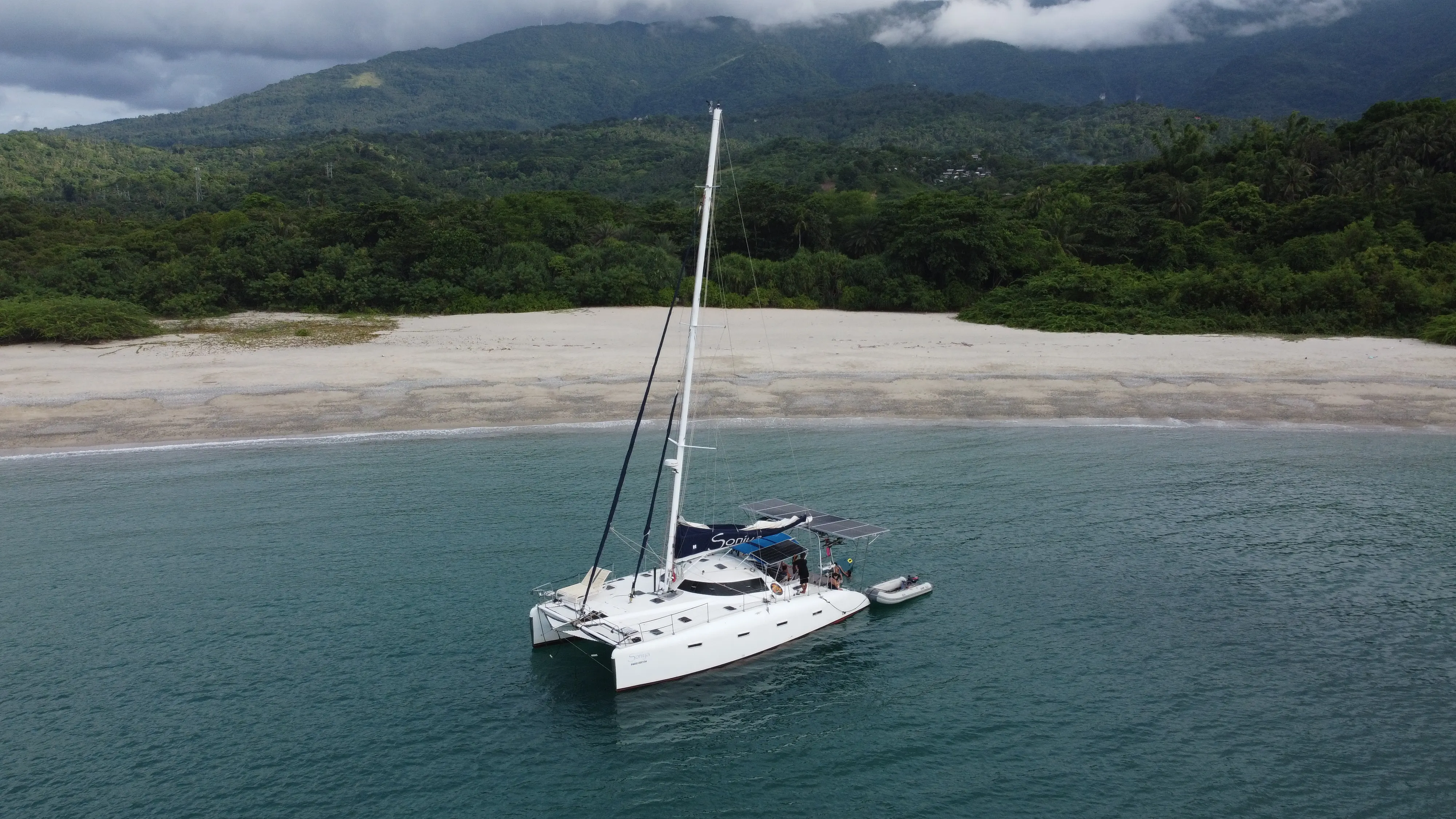 Guests on Soniya's deck while underway with a dinghy alongside
