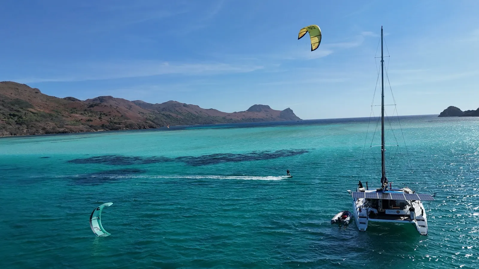 Golden-hour cliffs and lagoon with catamaran anchored