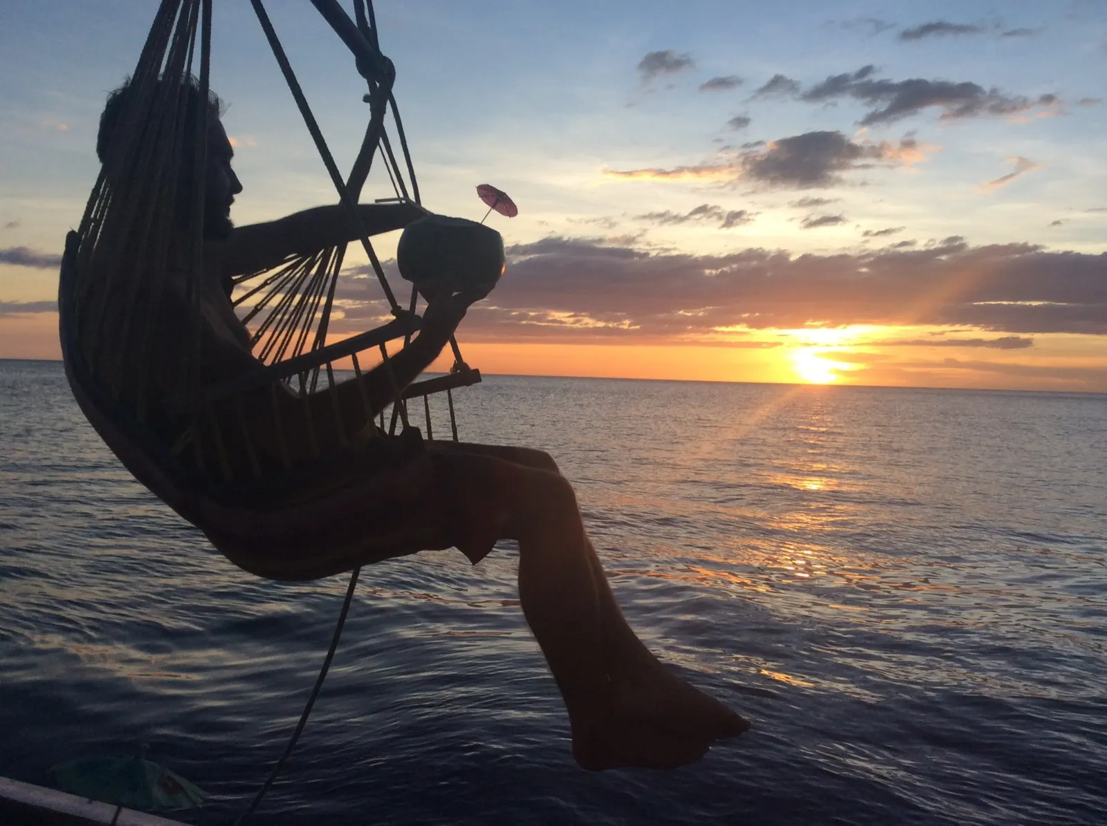 Silhouetted bimini and rigging against a boat sunset