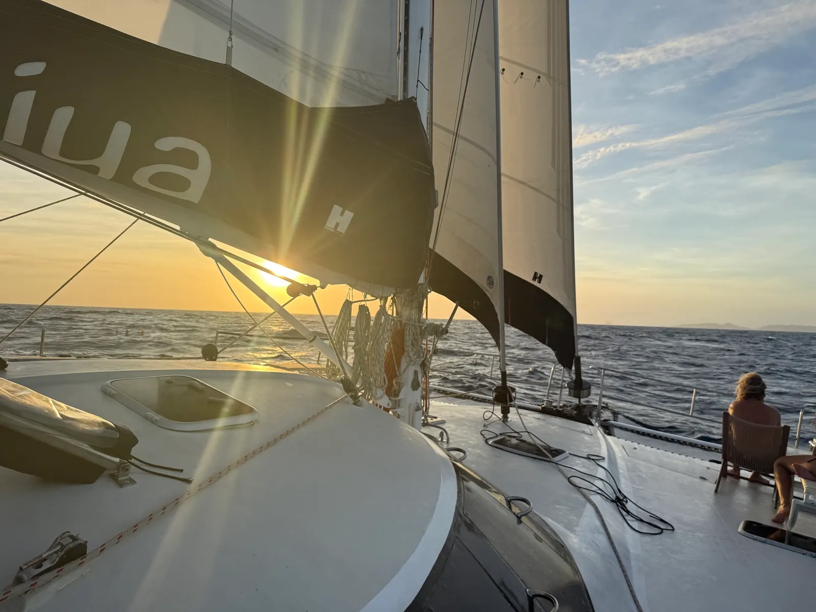 Sailing at sunset, crew relaxing on deck