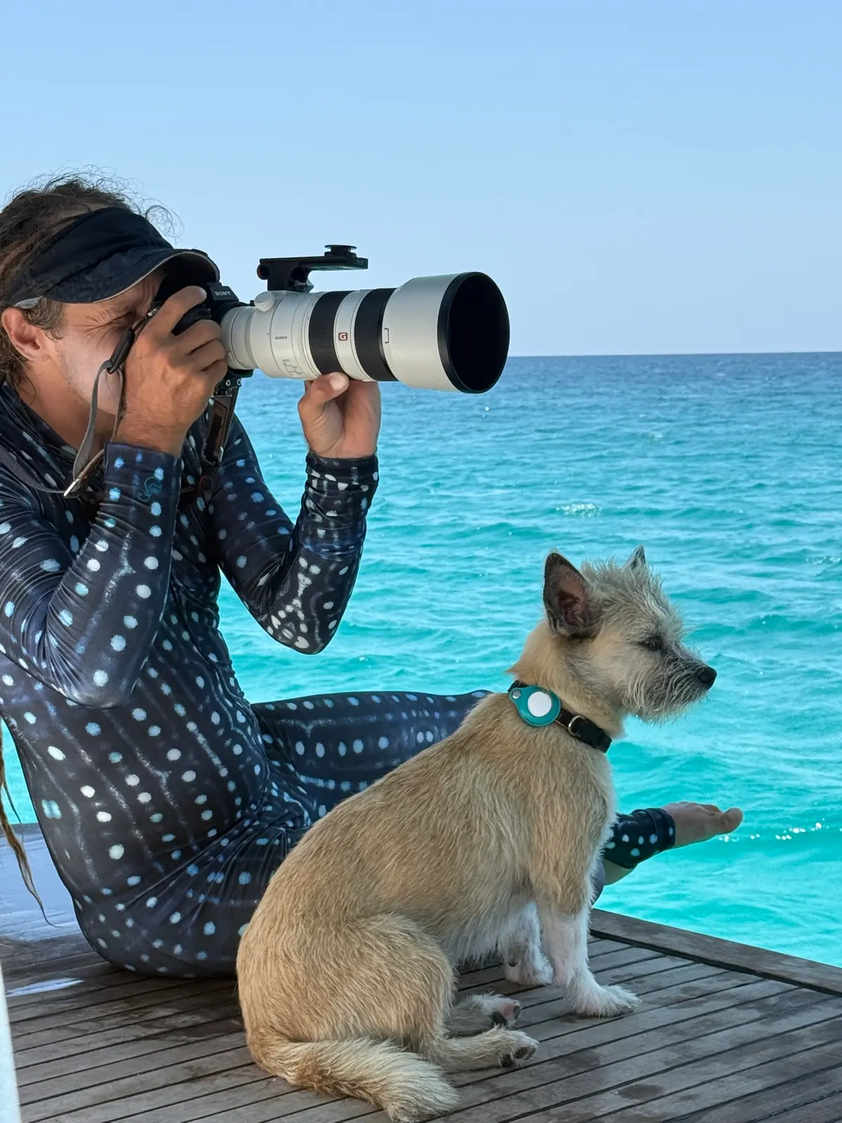 Man photographing dog on deck with telephoto lens